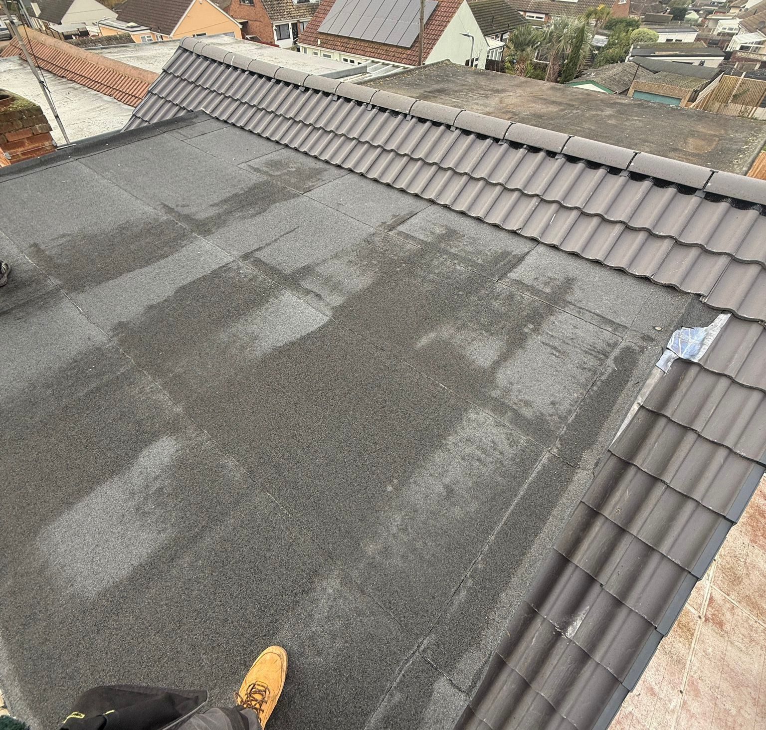 Newly laid grey roof tiles viewed across the slope