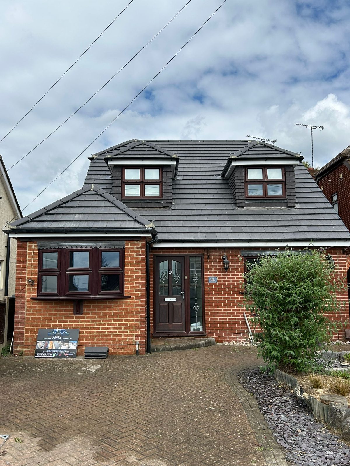Completed project — detached brick home with a new roof and driveway
