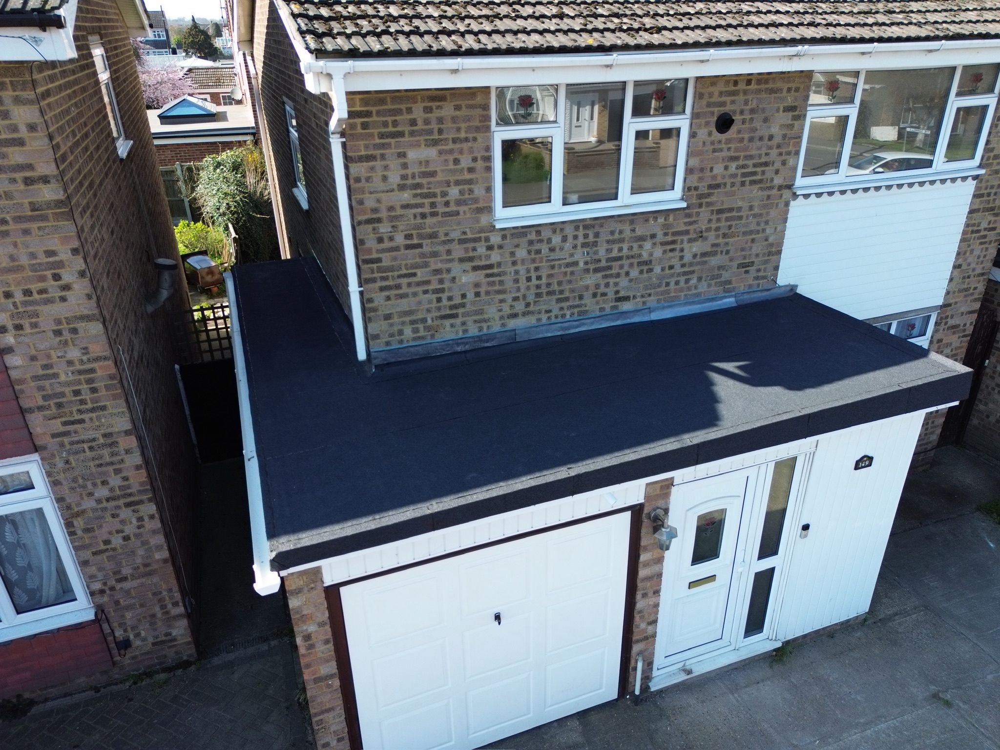 Black fibreglass GRP flat roof over a garage and porch